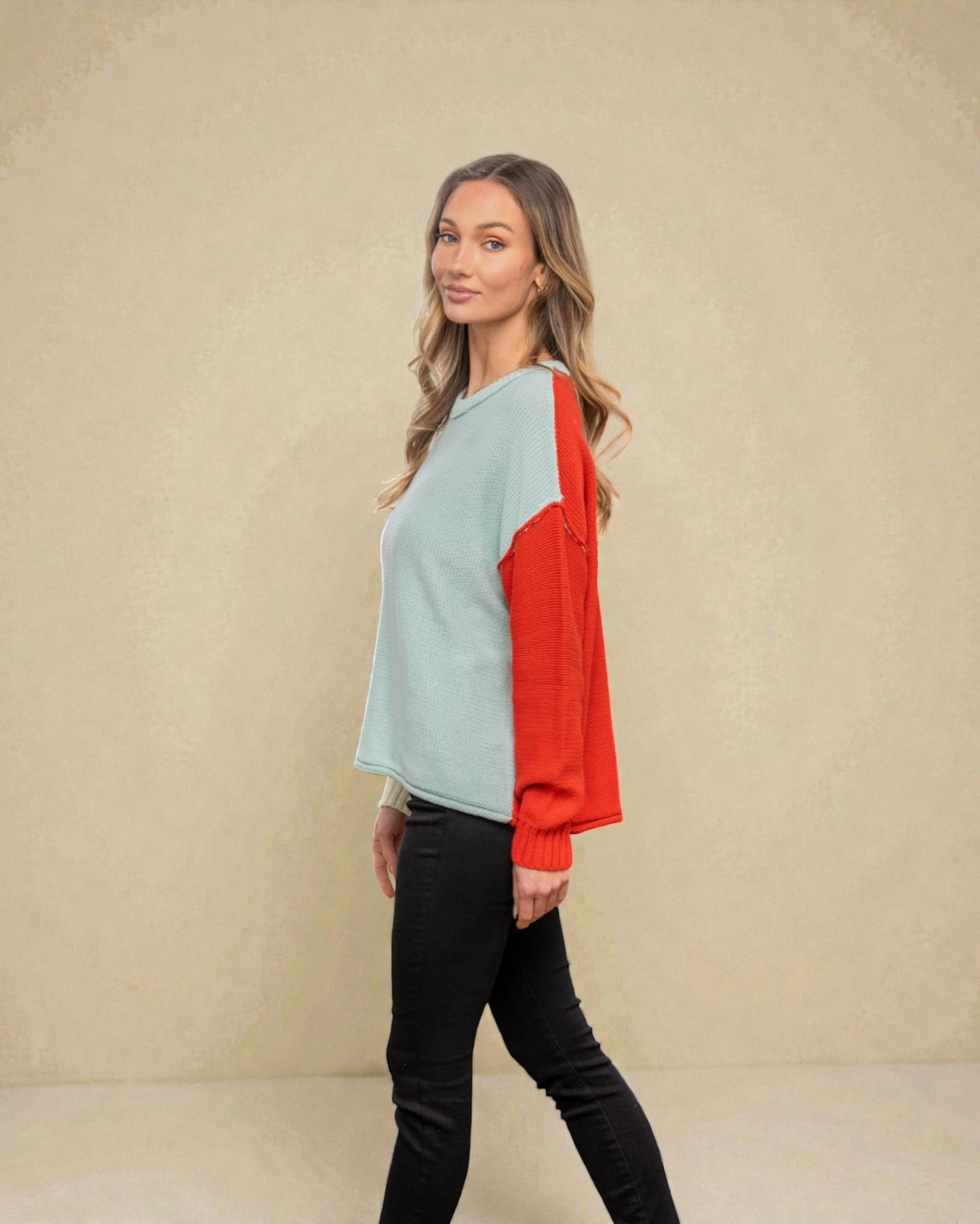 Woman wearing a light blue and red top against a beige background