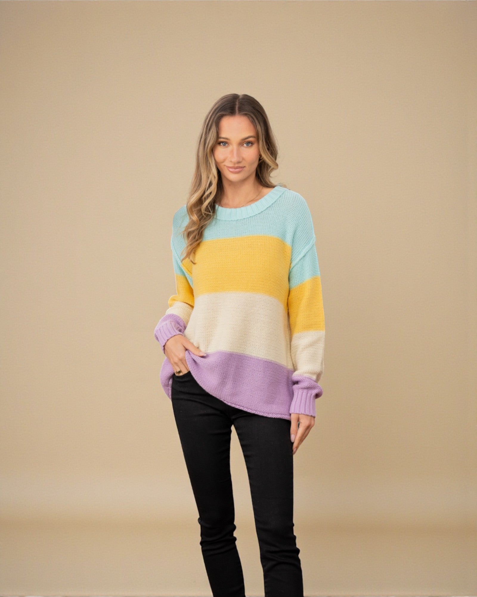 Woman wearing a colorful sweater with a beige background