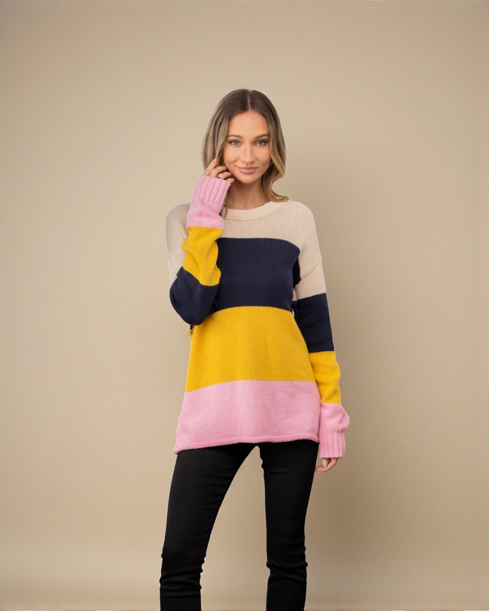 Woman wearing a colorful sweater with a beige background