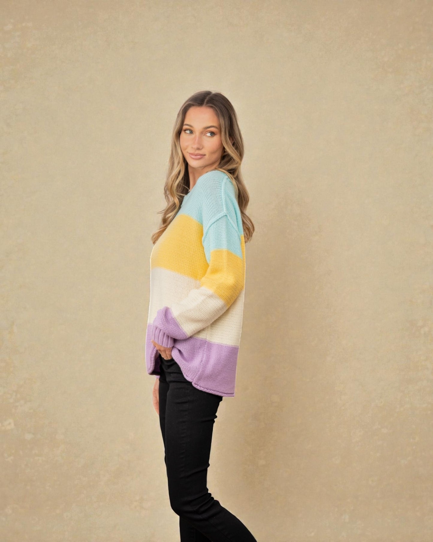 Woman wearing a colorful sweater against a beige background