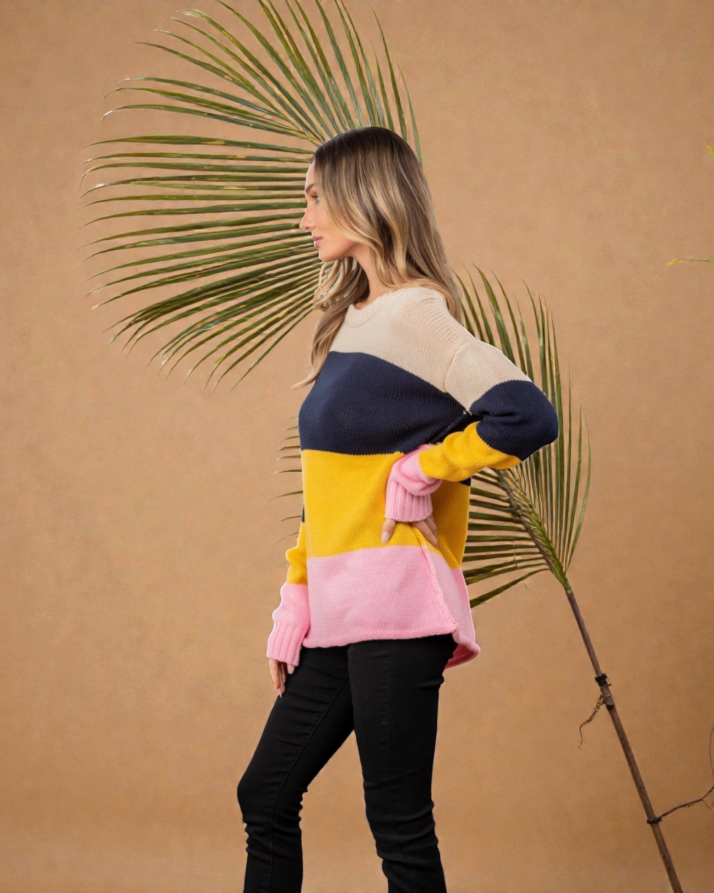 Woman wearing a colorful sweater with a palm leaf against a beige background