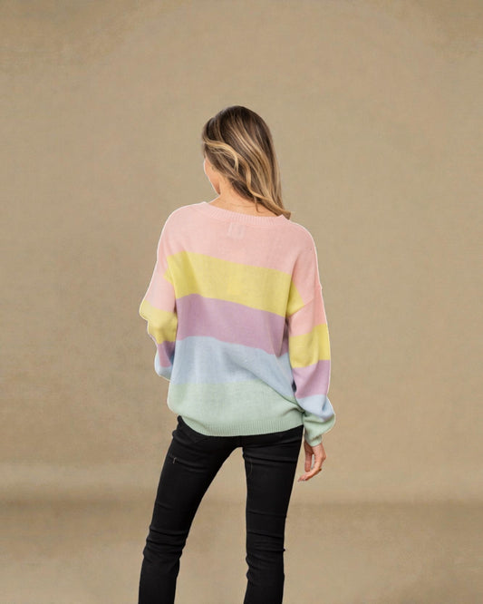 Person wearing a pastel striped sweater against a beige background