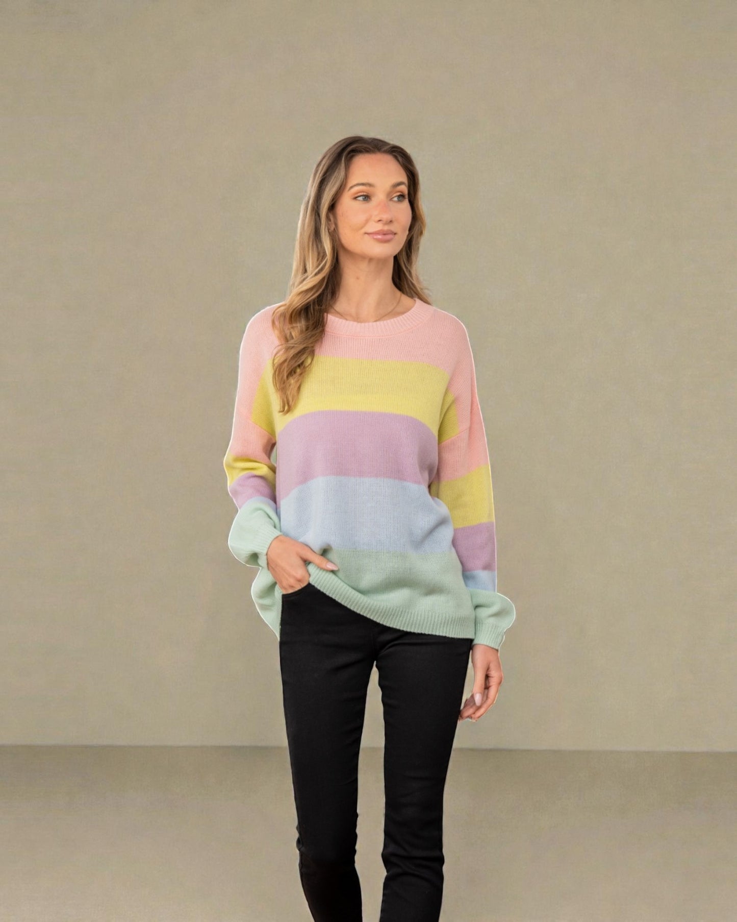 Woman wearing a pastel striped sweater against a plain background