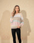 Woman wearing a pastel striped sweater against a beige background
