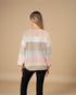 Person wearing a pastel striped sweater on a beige background