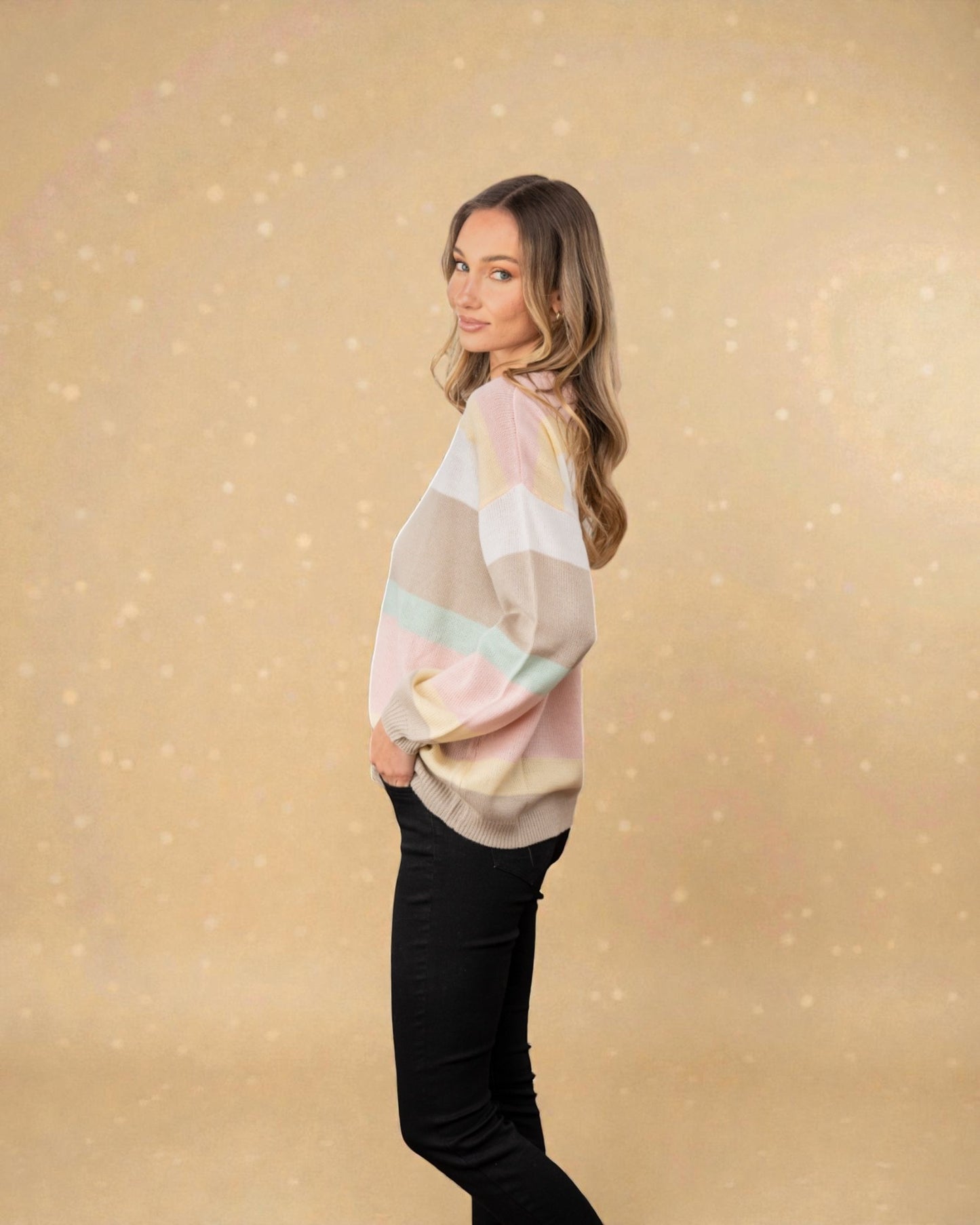 Woman wearing a pastel-colored sweater against a beige background