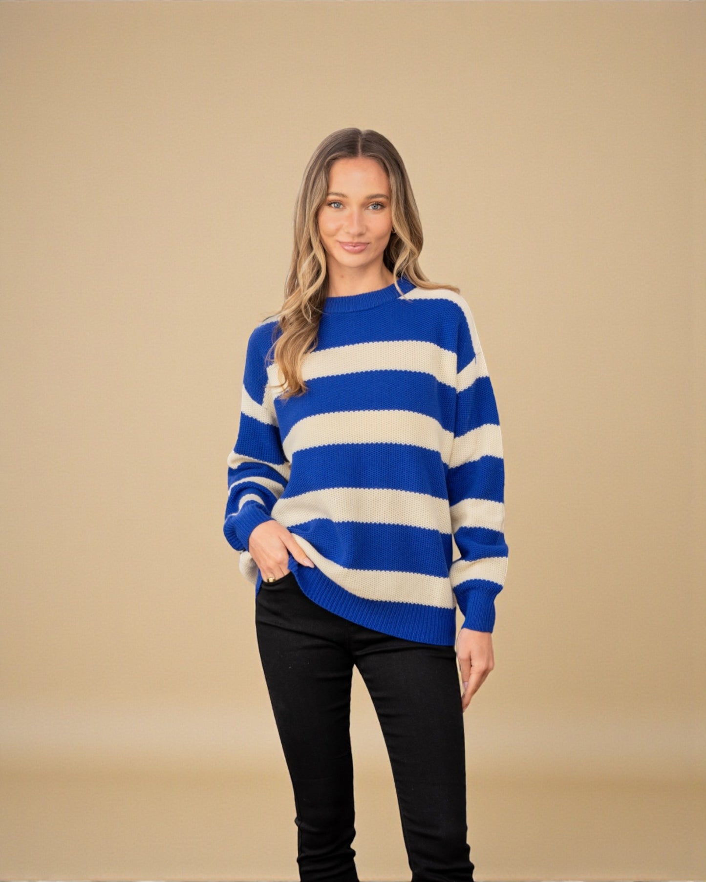 Woman wearing a blue and white striped sweater against a beige background
