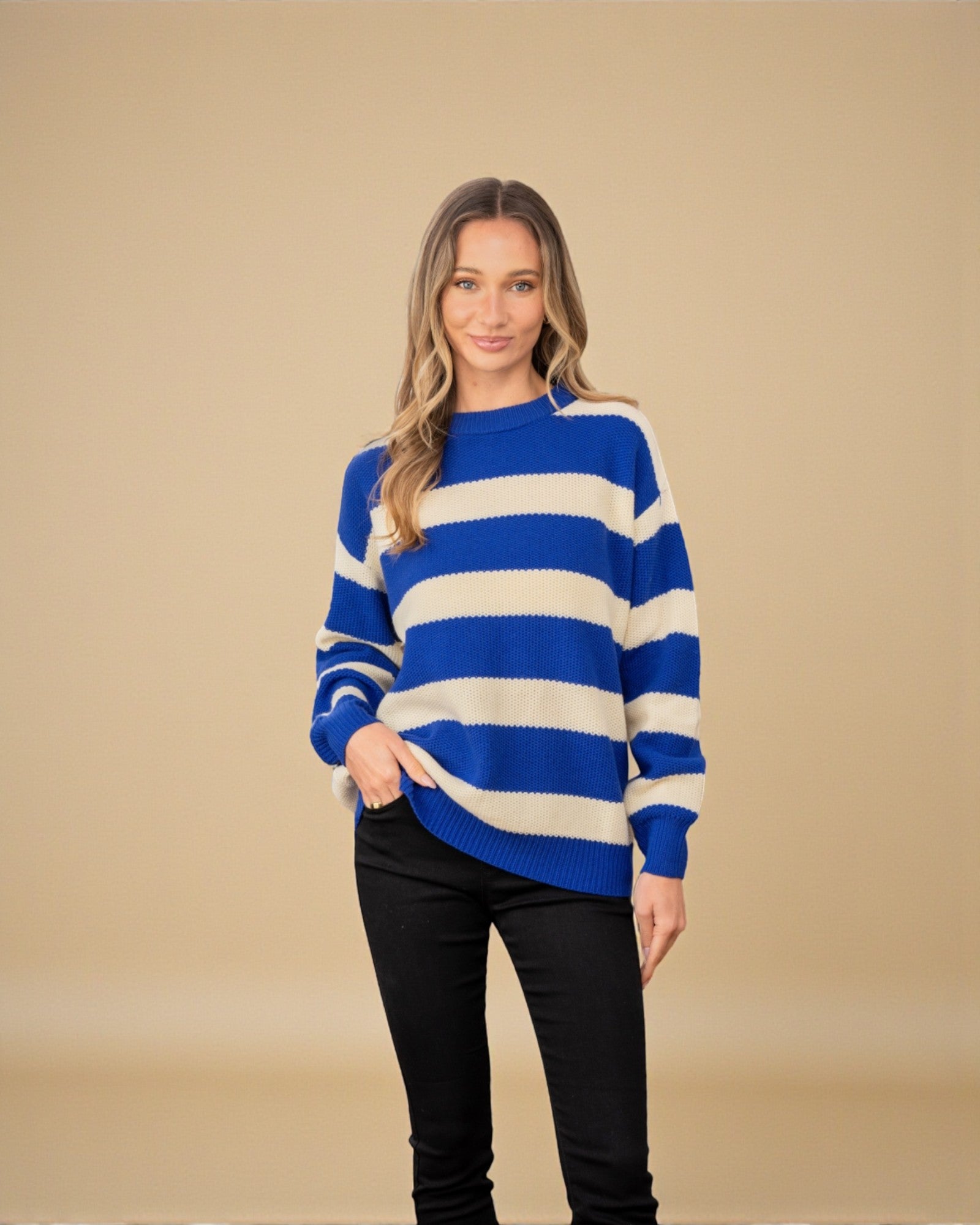 Woman wearing a blue and white striped sweater against a beige background