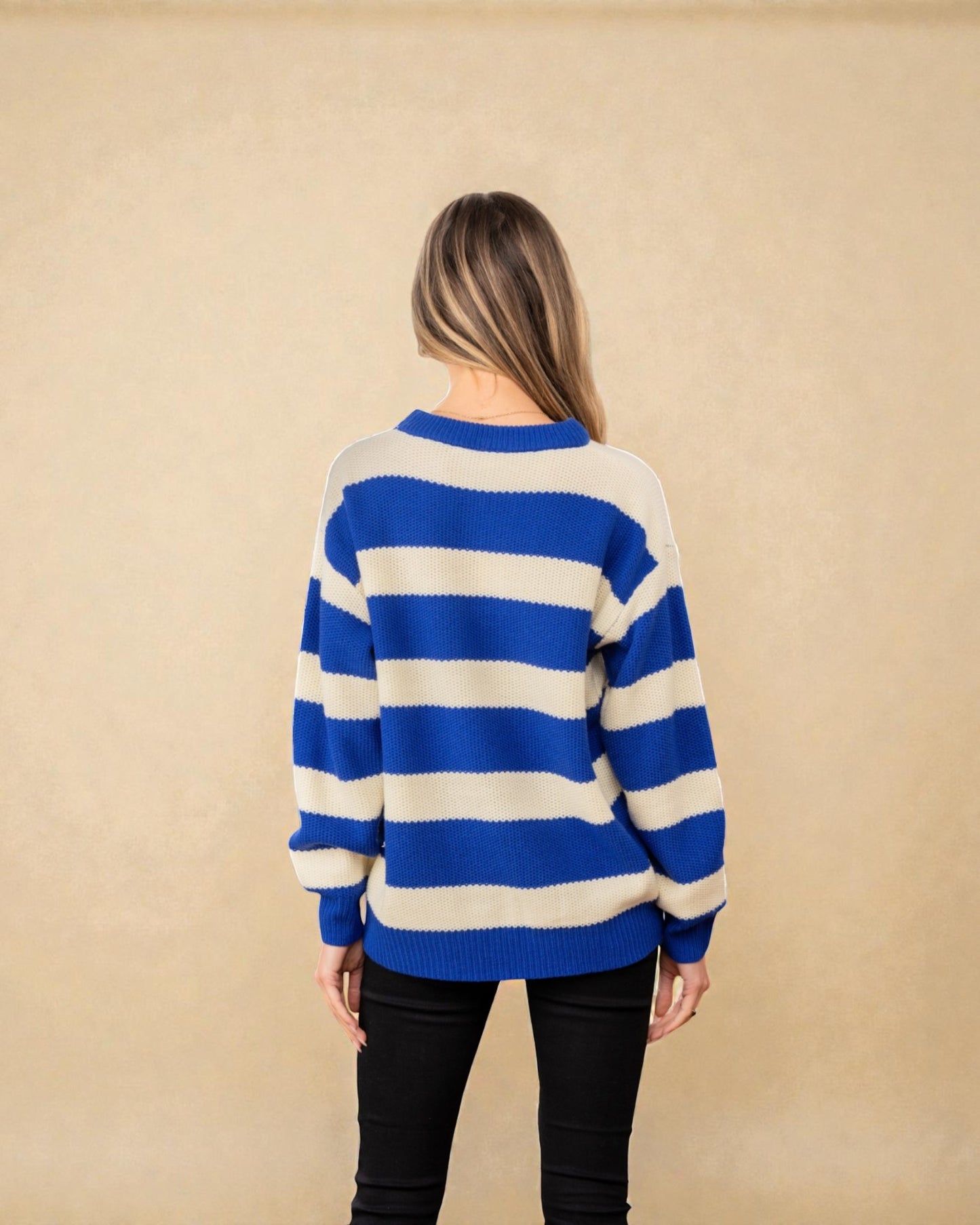 Person wearing a blue and white striped sweater against a beige background
