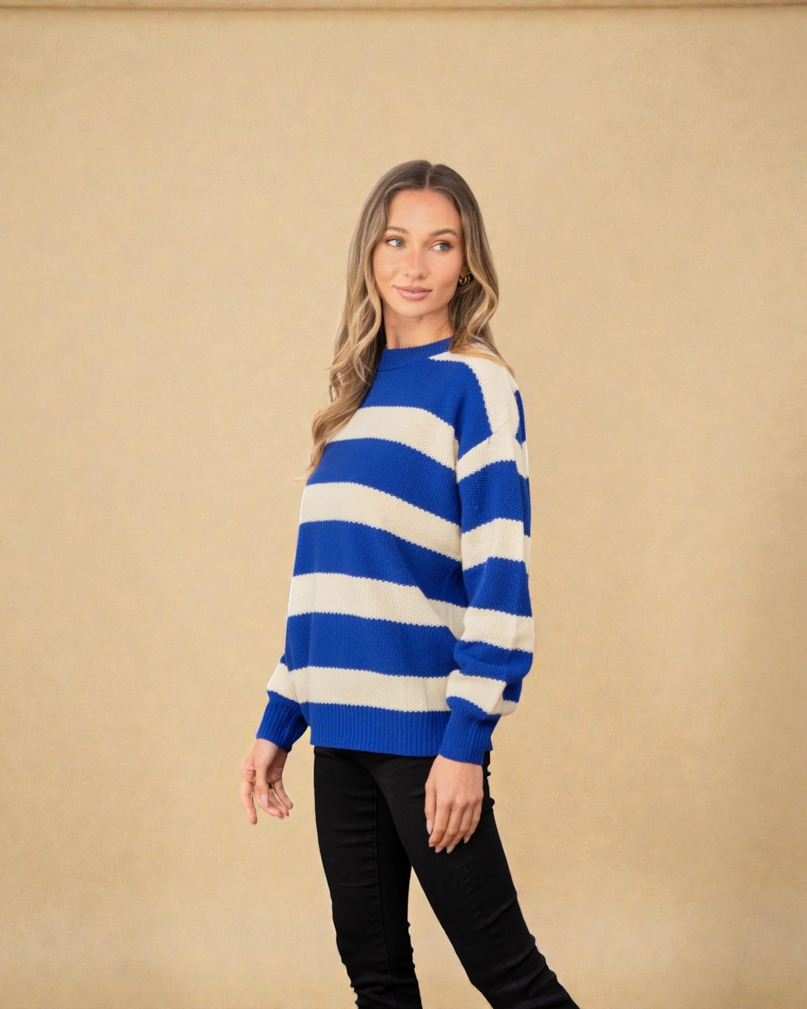 Woman wearing a blue and white striped sweater against a beige background