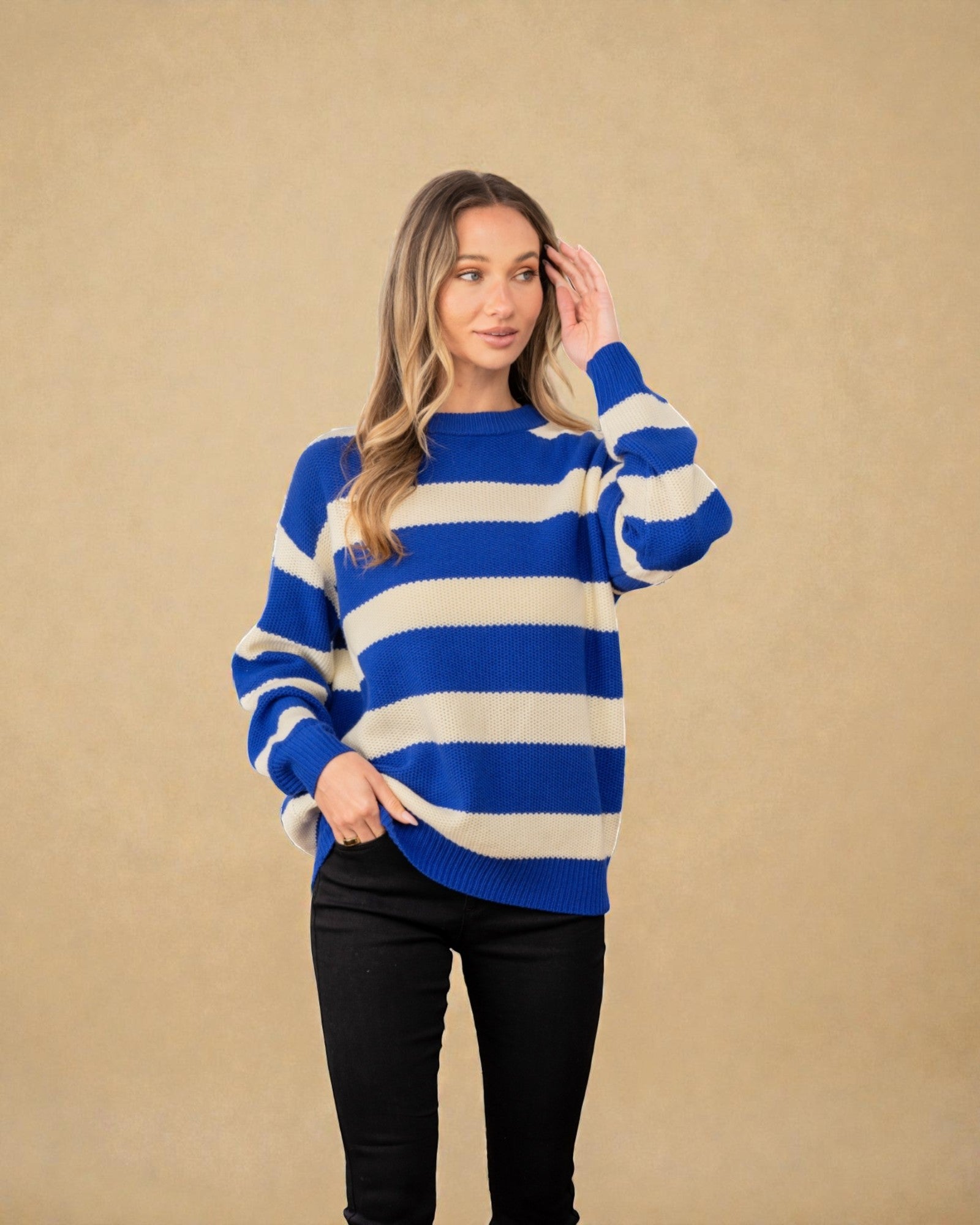 Woman wearing a blue and white striped sweater against a beige background