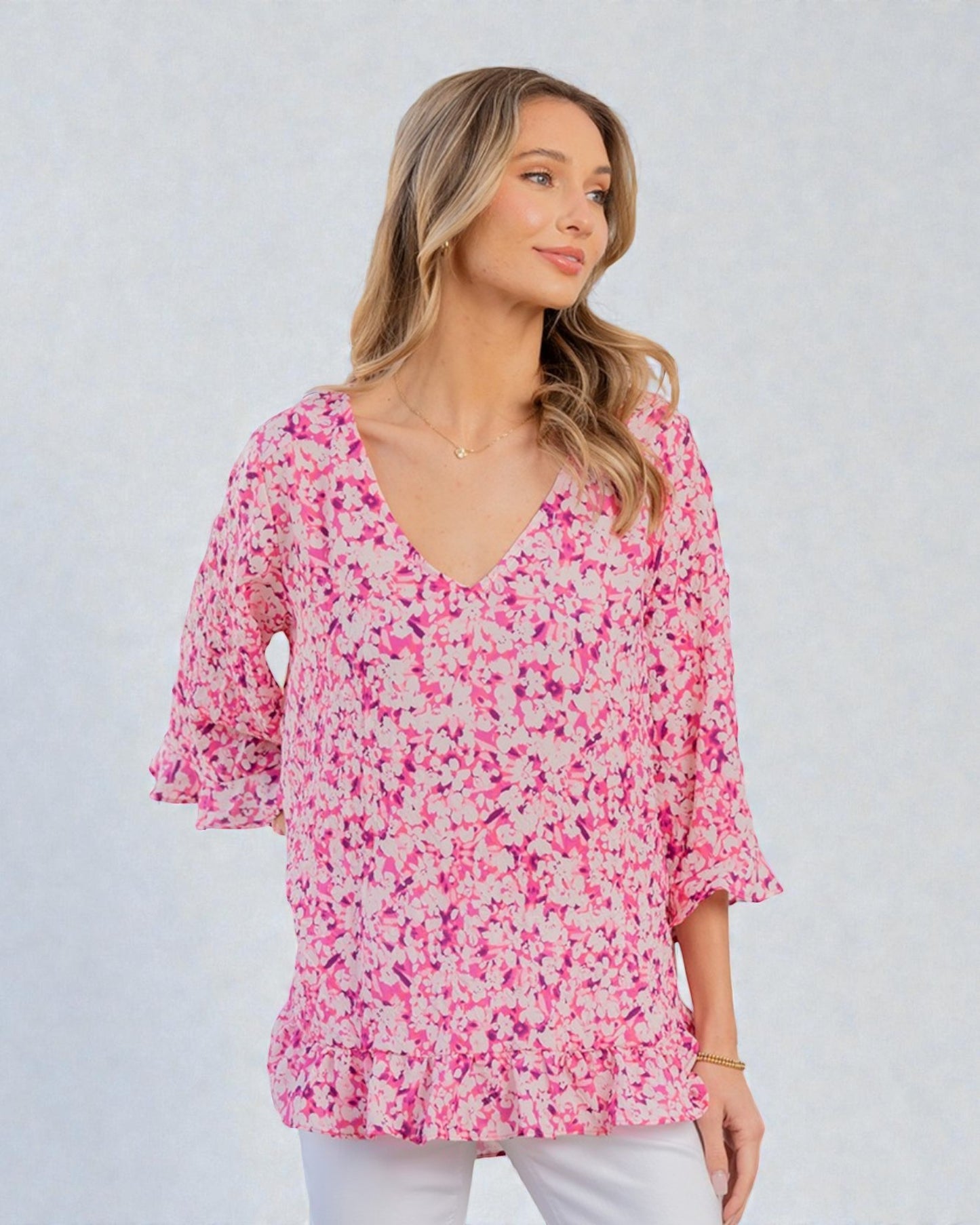 Woman wearing a pink floral blouse against a white background