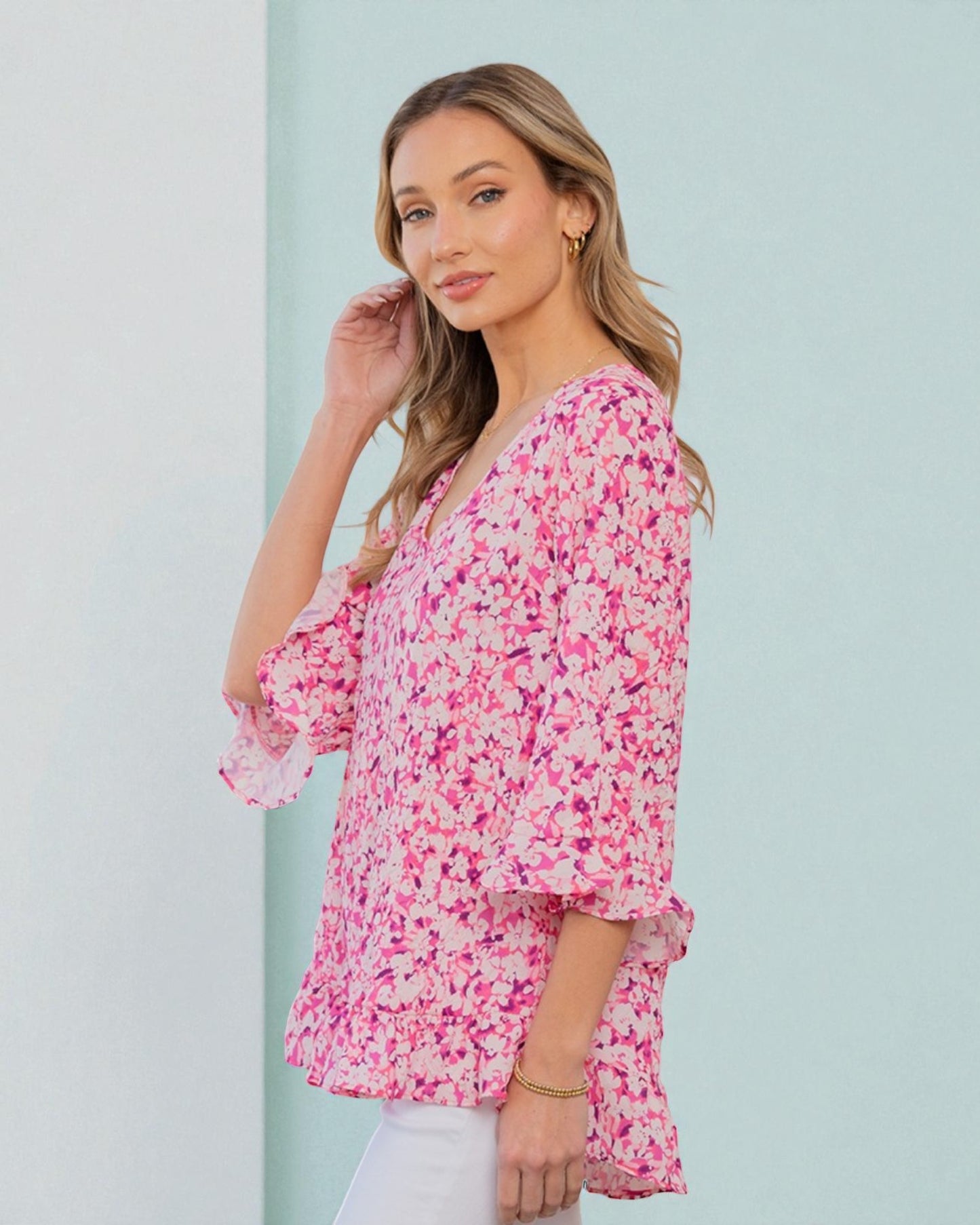 Woman wearing a pink floral blouse against a light blue background