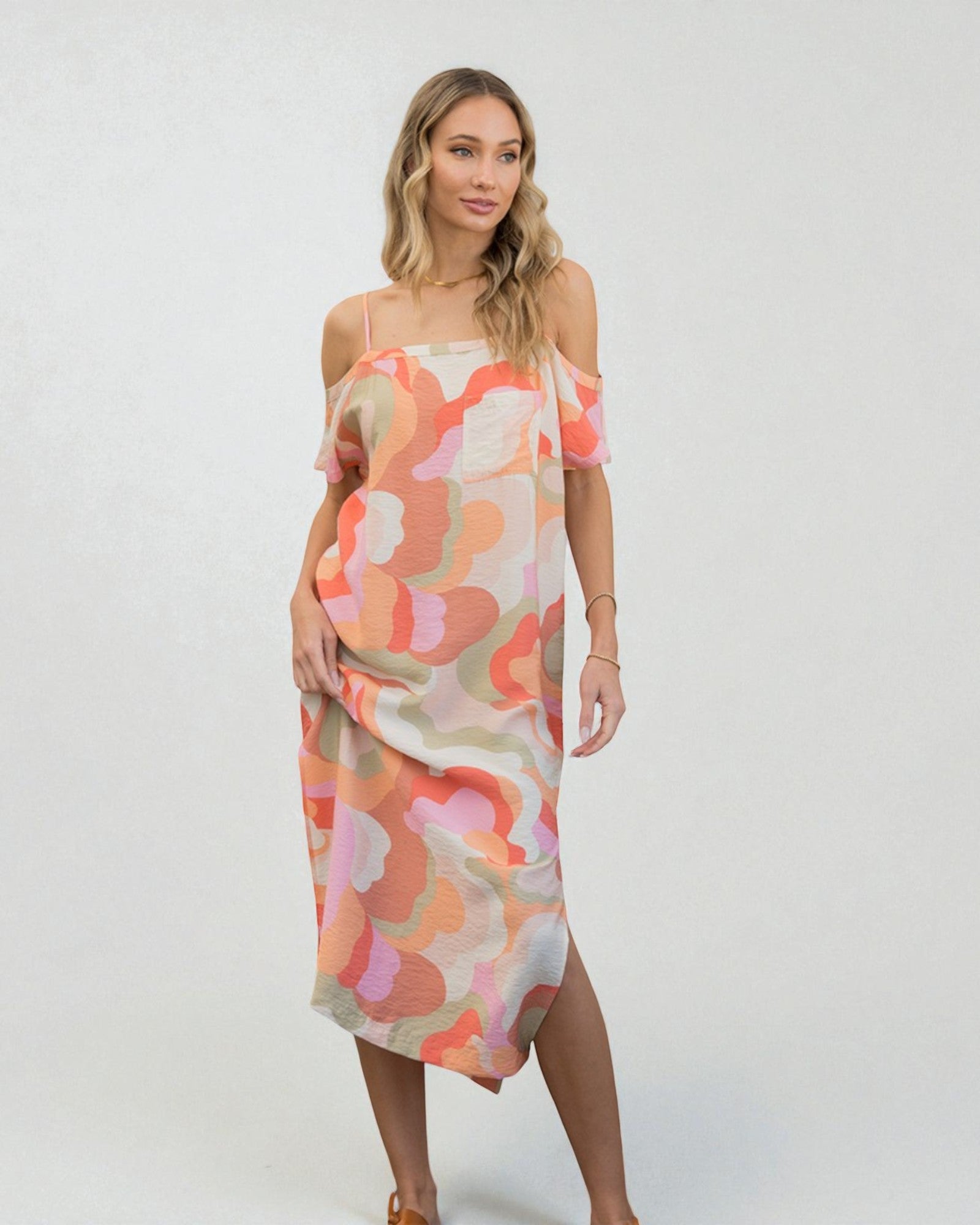 Woman wearing a colorful patterned dress on a white background