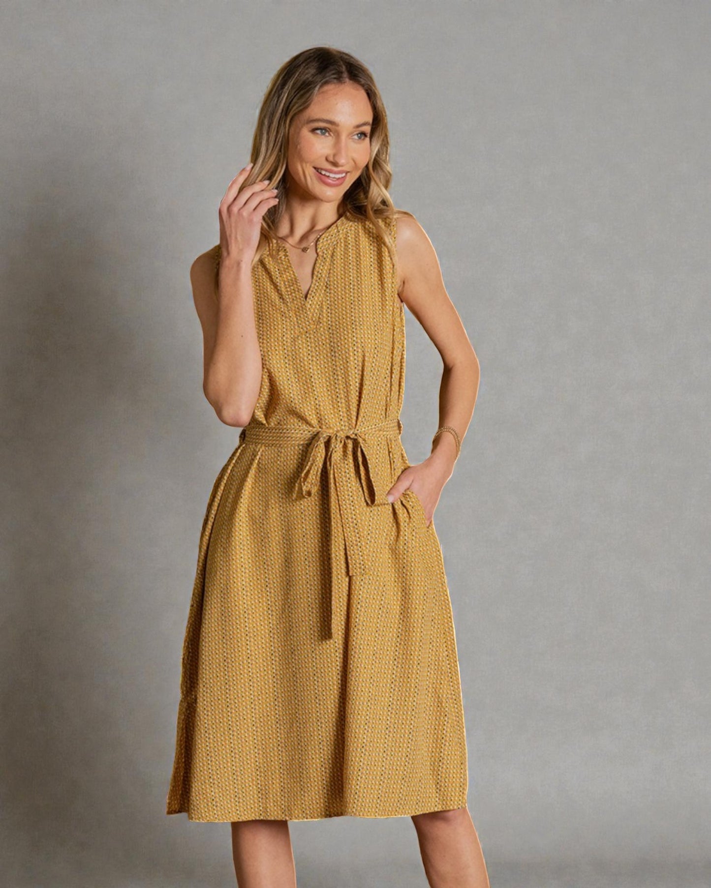Woman wearing a yellow dress against a gray background