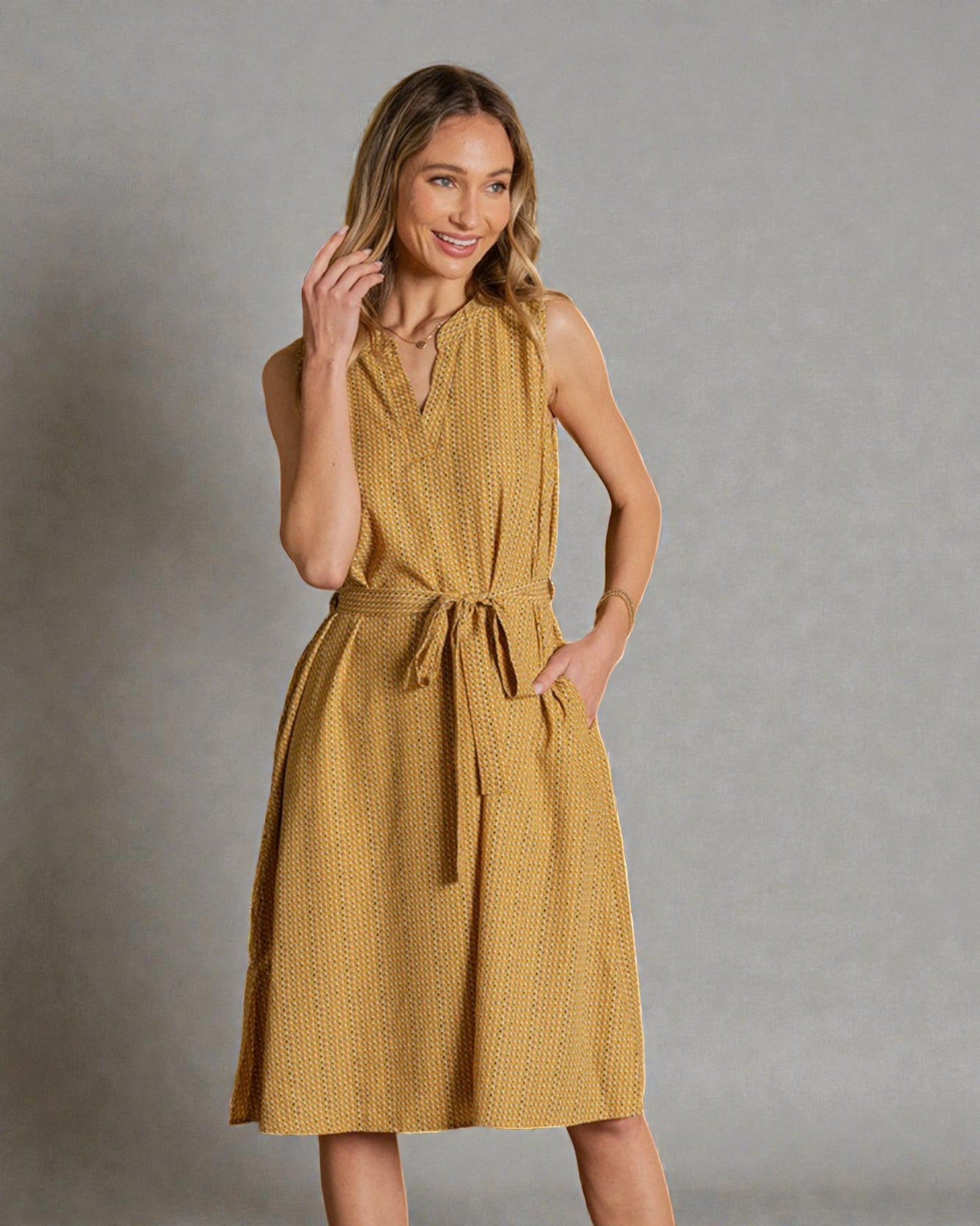 Woman wearing a yellow dress against a gray background