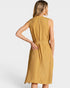 A woman shown from the back wearing a sleeveless midi dress with a textured, woven mustard yellow and white pattern. The dress features a high neckline and a matching fabric tie belt at the waist, set against a plain light gray studio background.