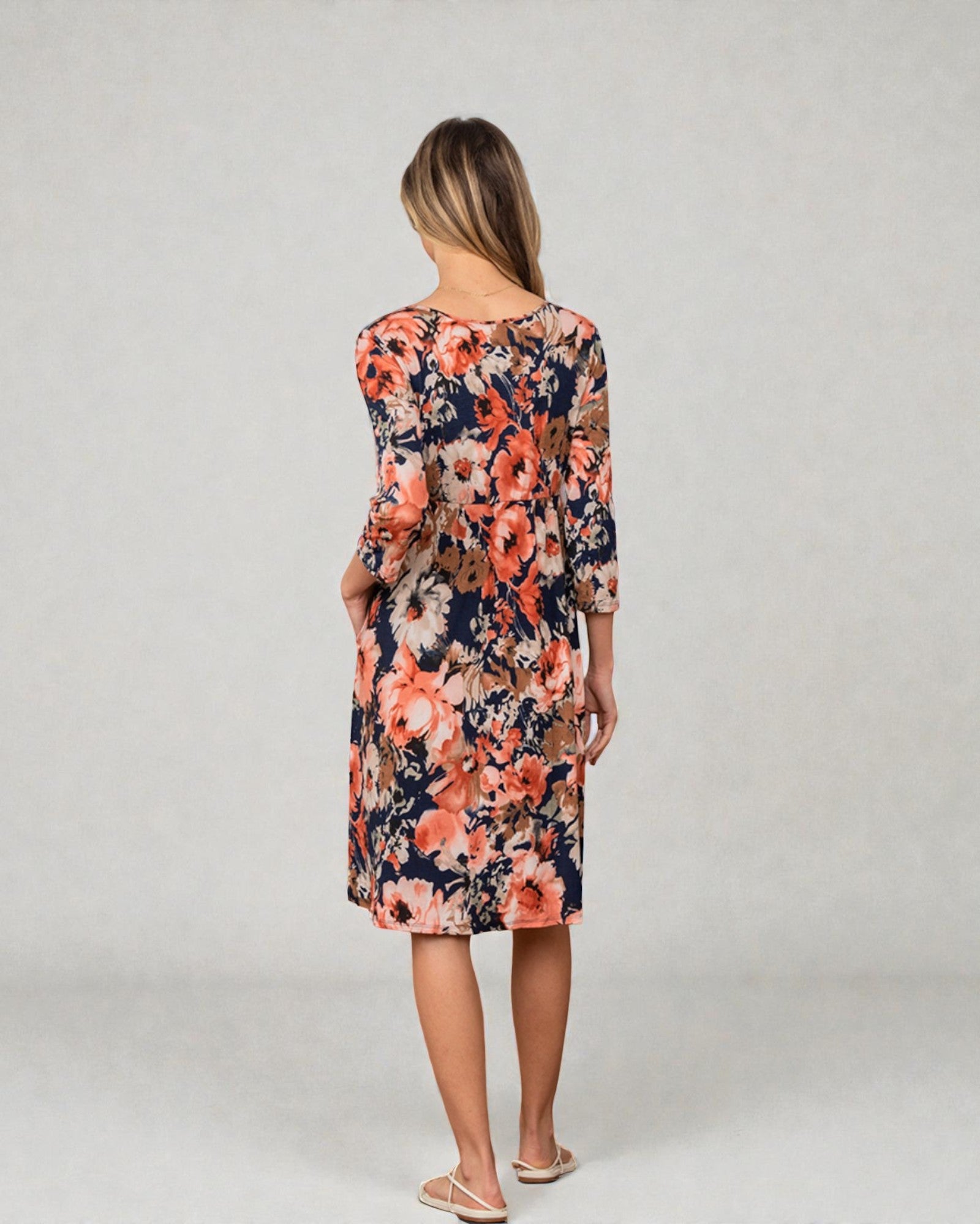 Woman wearing a floral dress on a plain background