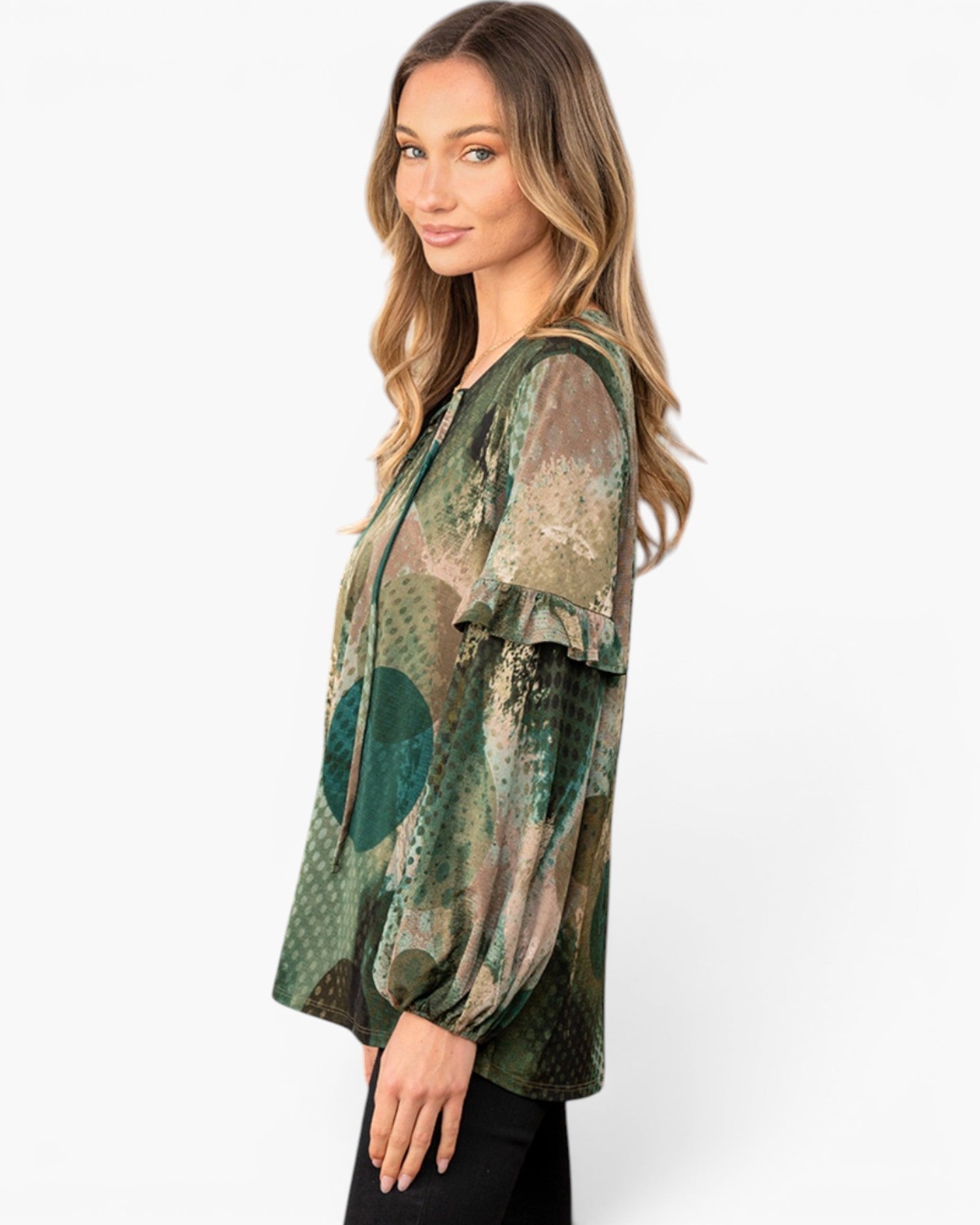 A woman wearing a sheer long-sleeve blouse with a green, brown, and beige abstract pattern, shown from a side profile against a light gray studio background.