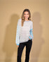 Woman wearing a striped sweater against a beige background