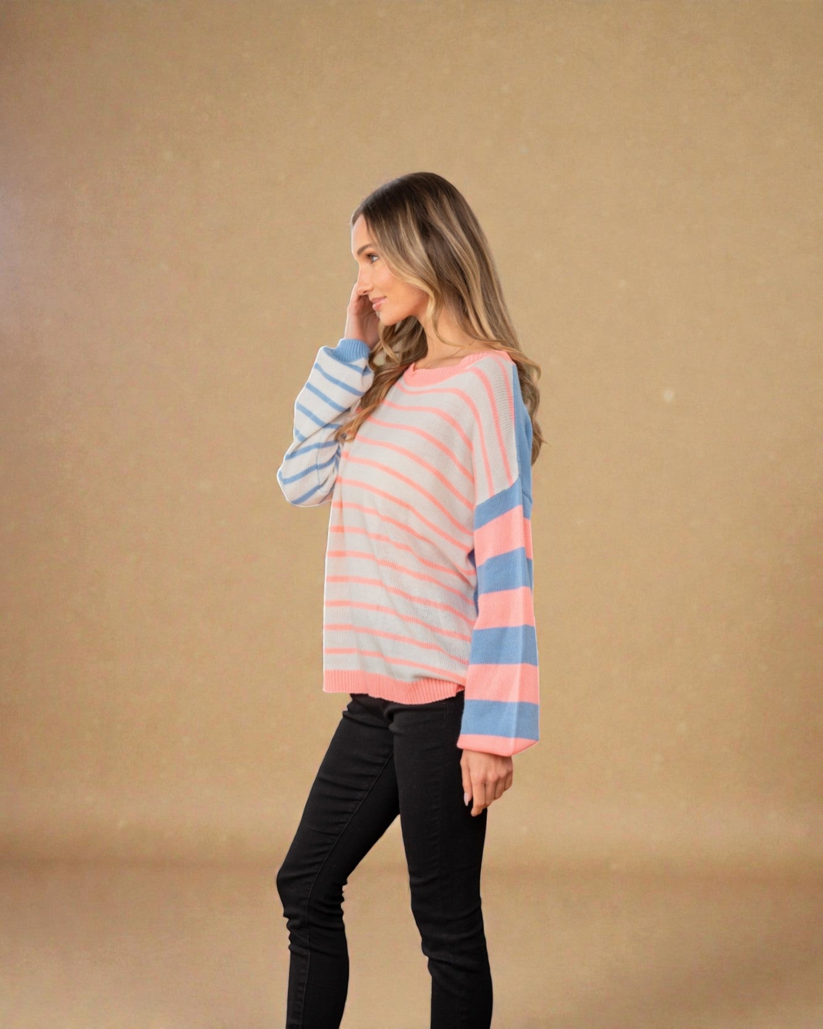 Woman wearing a striped sweater against a beige background