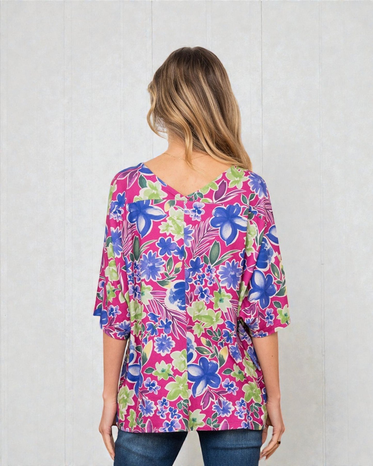 Woman wearing a colorful floral blouse against a white background