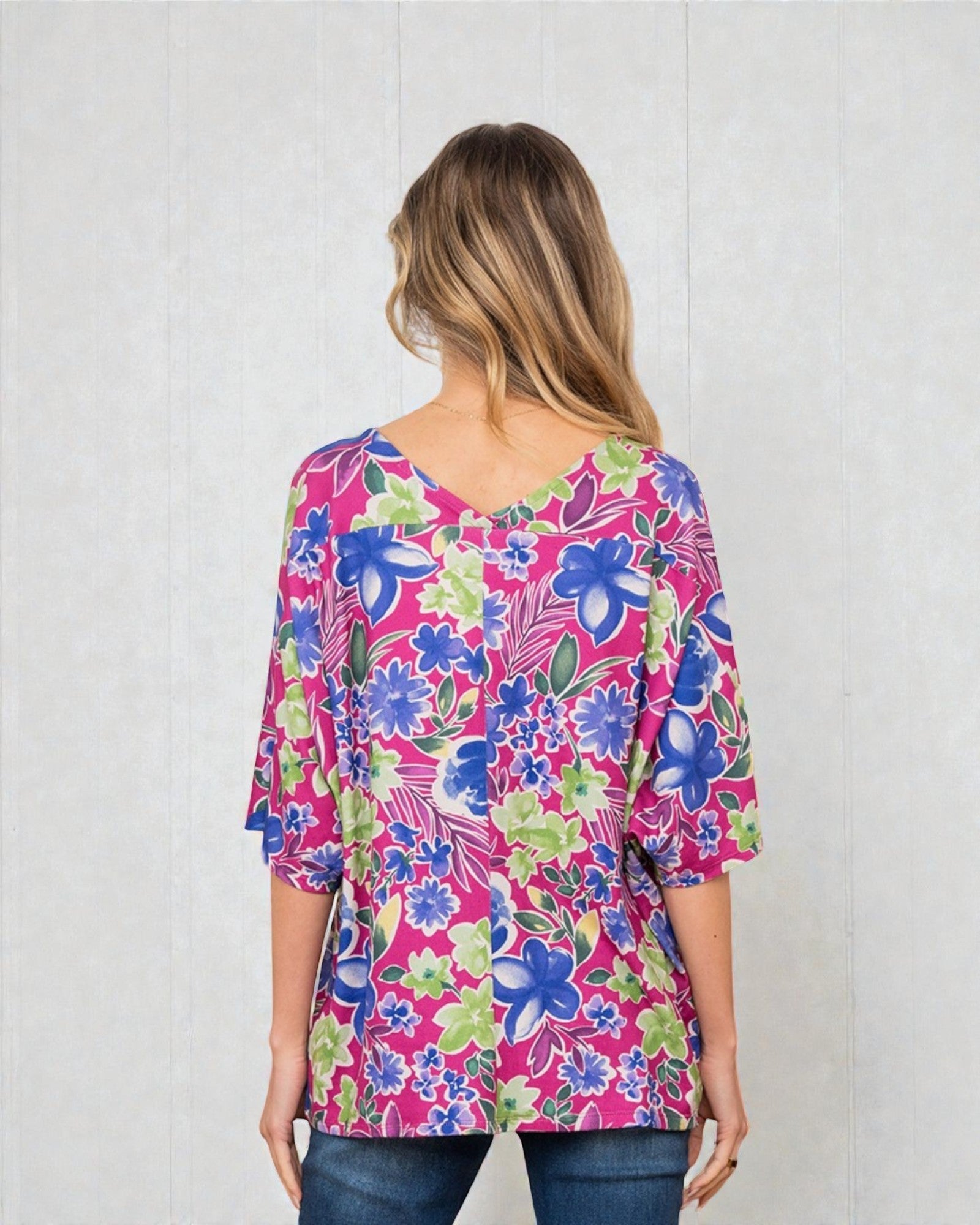 Woman wearing a colorful floral blouse against a white background