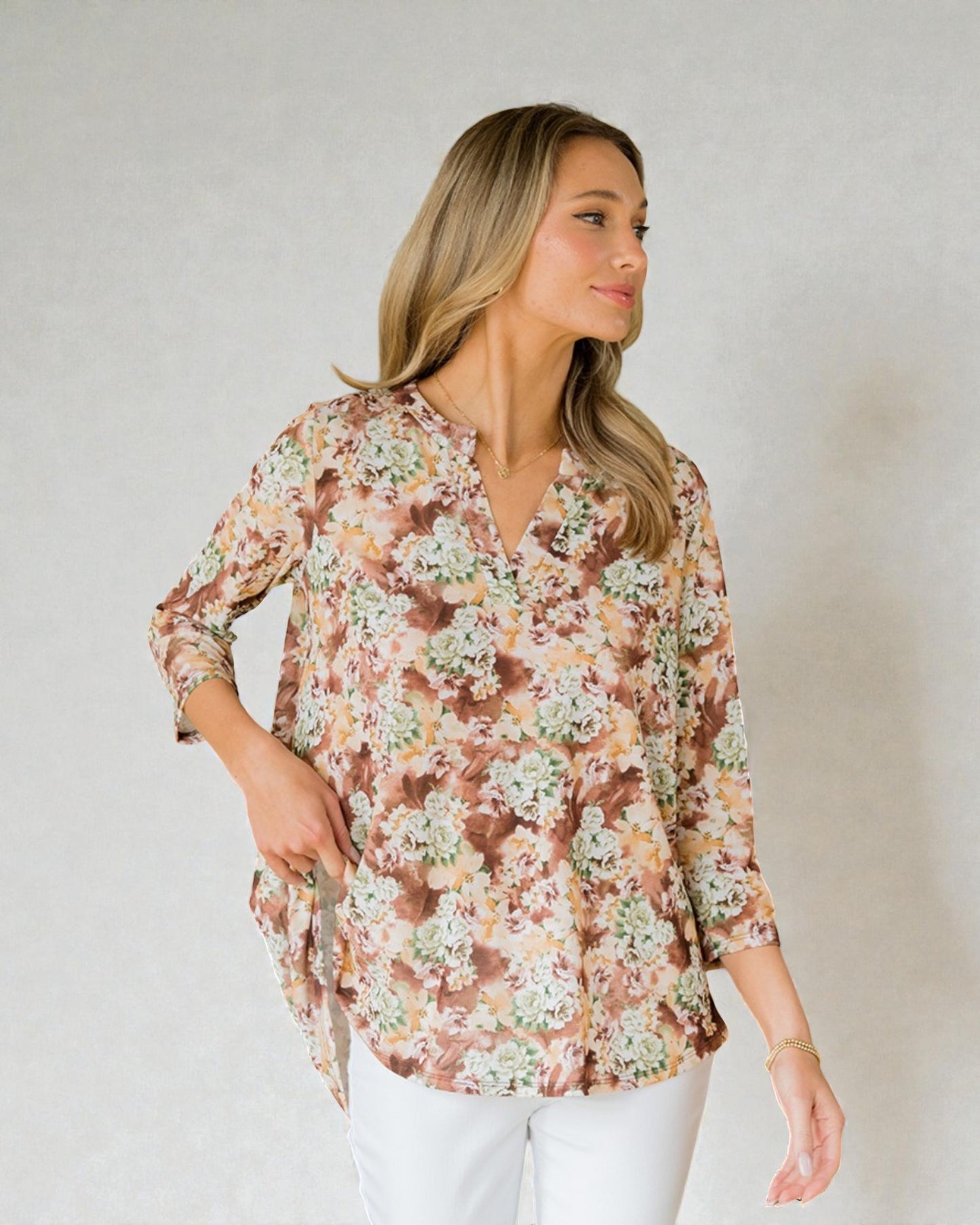 Woman wearing a floral blouse against a plain background