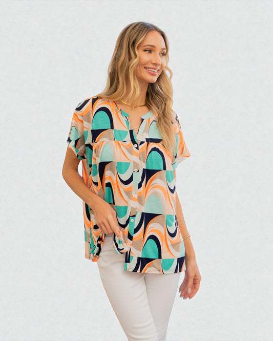 Woman wearing a patterned blouse with a plain background