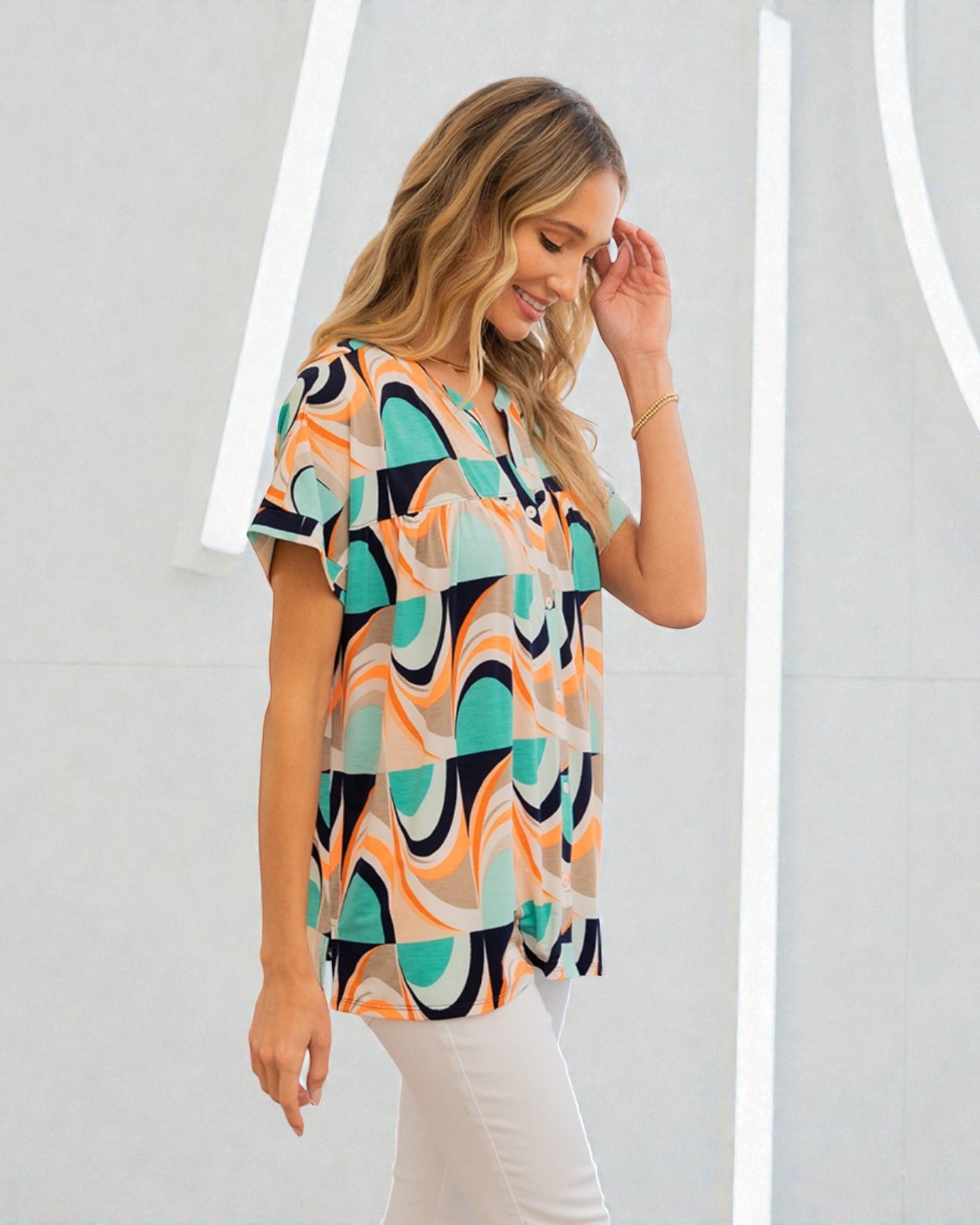 Woman wearing a colorful patterned blouse against a white background