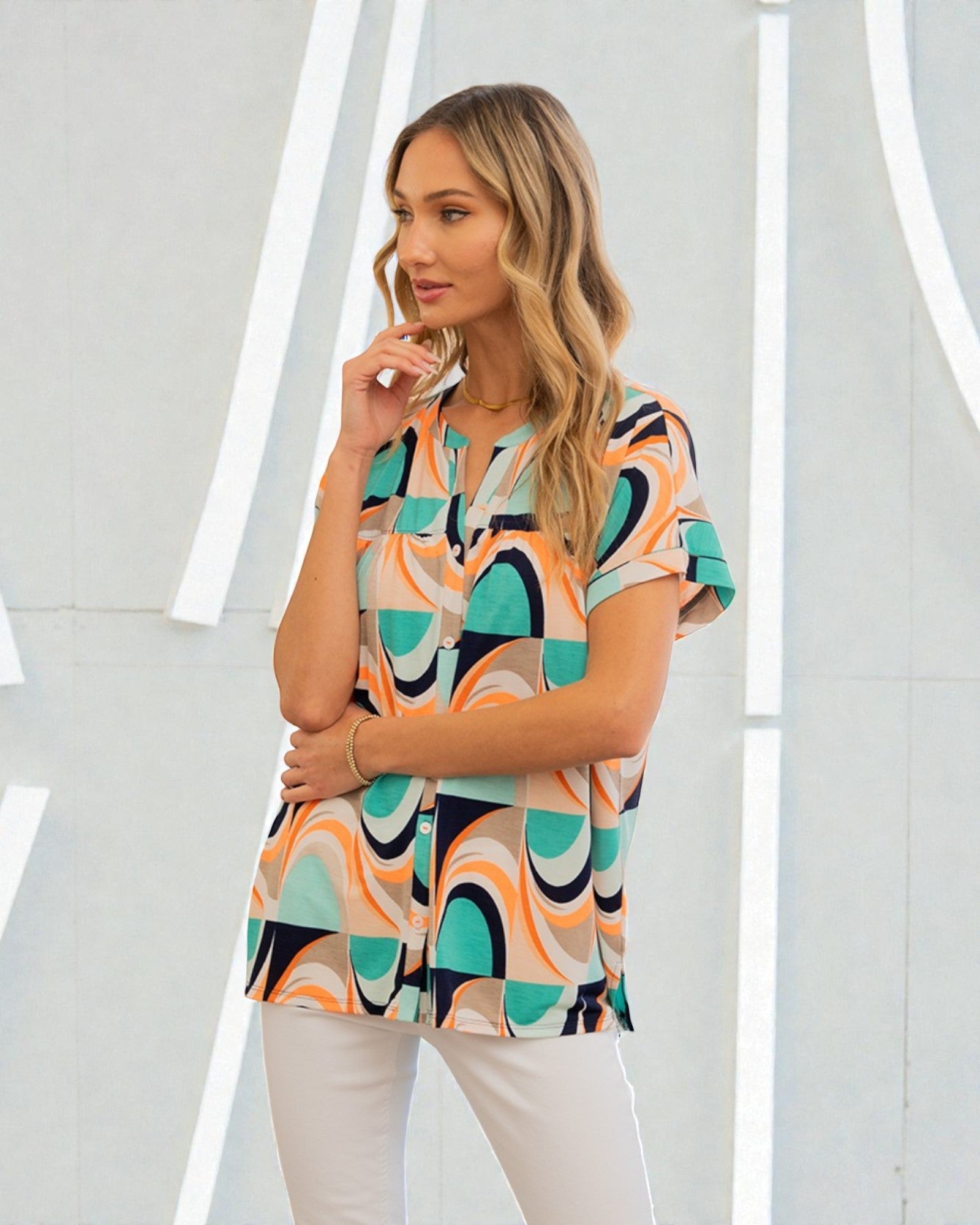 Woman wearing a colorful patterned top against a white background