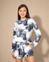 Woman wearing a tie-dye long-sleeve top and shorts set on a beige background