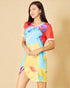 Woman wearing a colorful tie-dye dress on a beige background