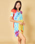 Woman wearing a colorful tie-dye dress against a beige background