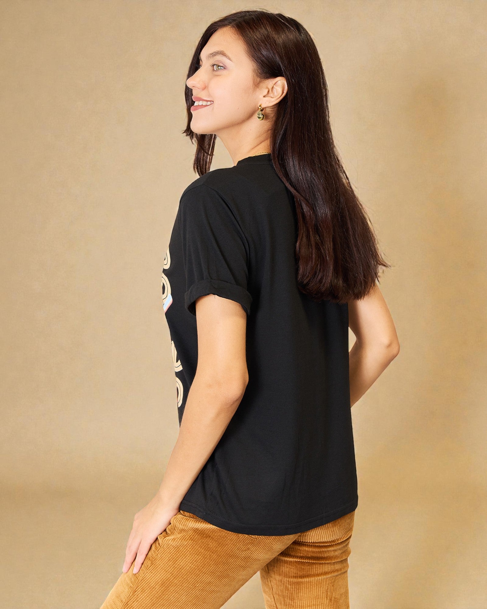 Woman wearing a black t-shirt with text on a beige background
