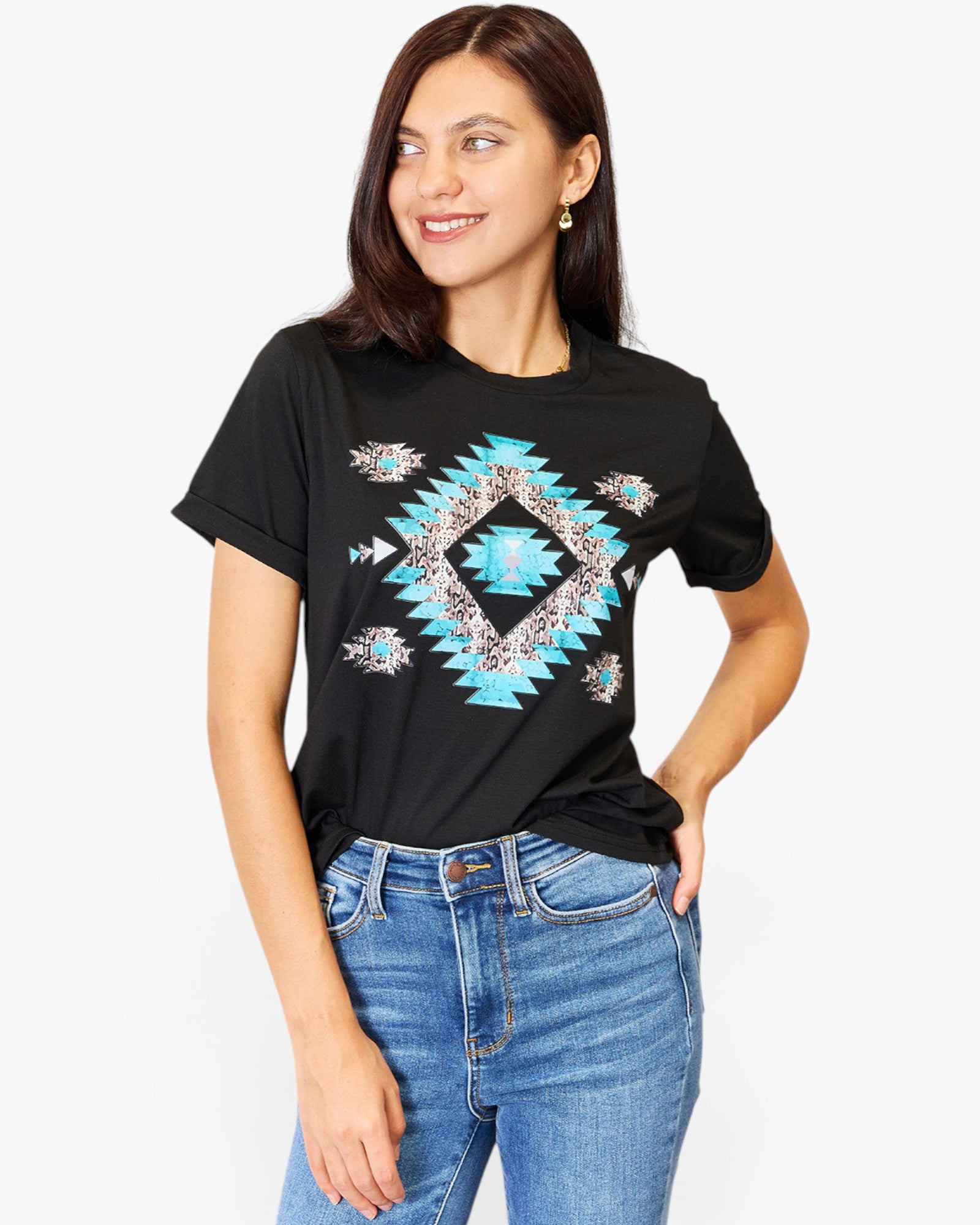 A woman wearing a black short-sleeve t-shirt with a colorful geometric diamond pattern in turquoise, beige, and white, paired with blue jeans, against a plain white background.