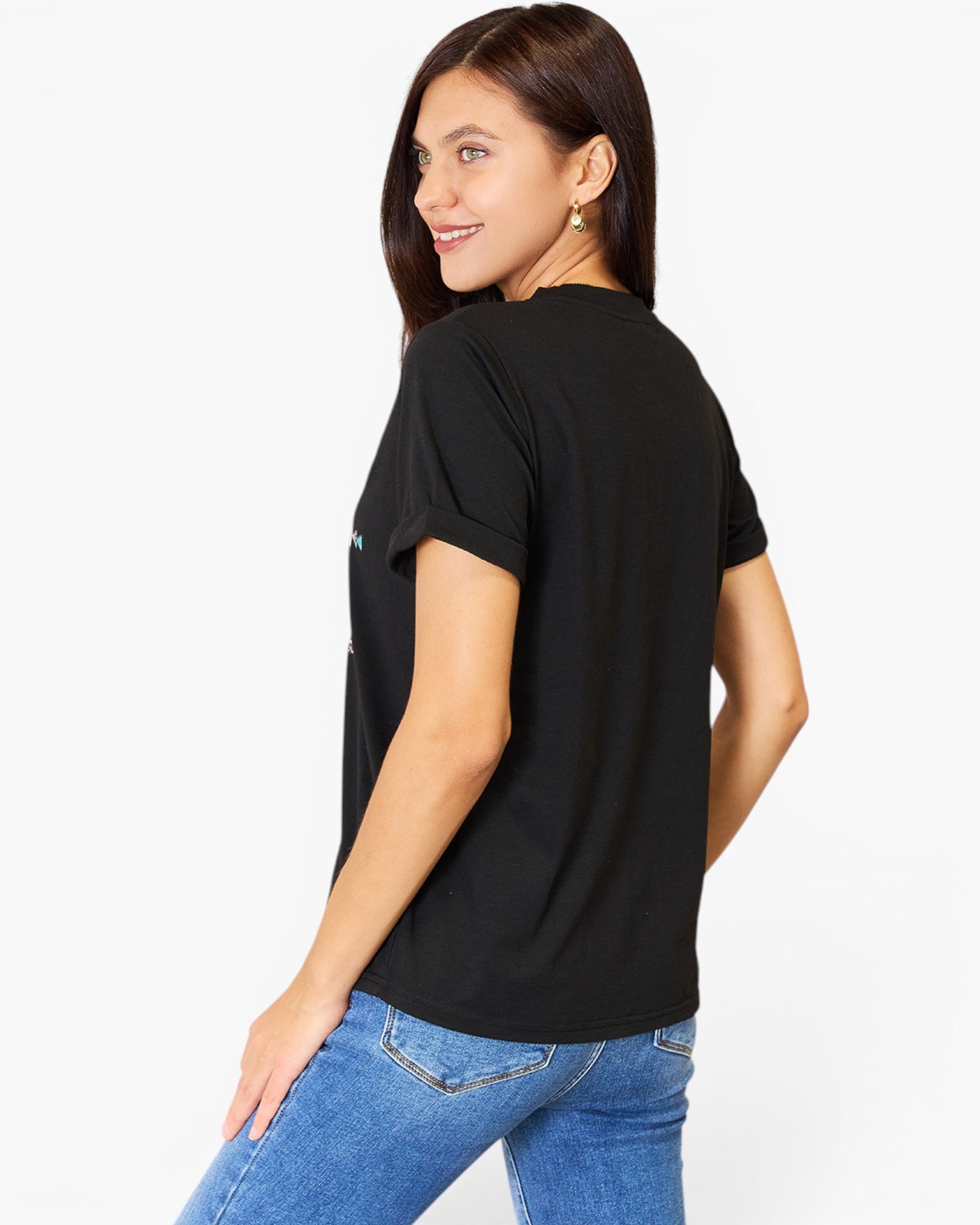 A woman wearing a black short-sleeve t-shirt and blue jeans, shown from a three-quarters back view against a plain white studio background.