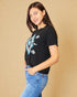Woman wearing a black t-shirt with a blue graphic design on a beige background