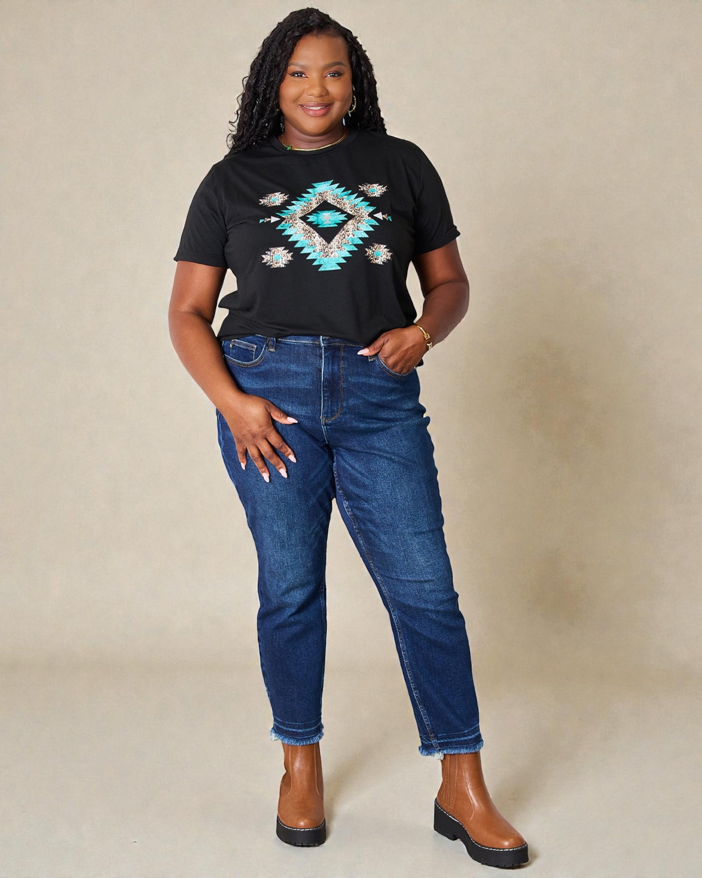 Woman wearing a black t-shirt with a geometric design and blue jeans on a beige background