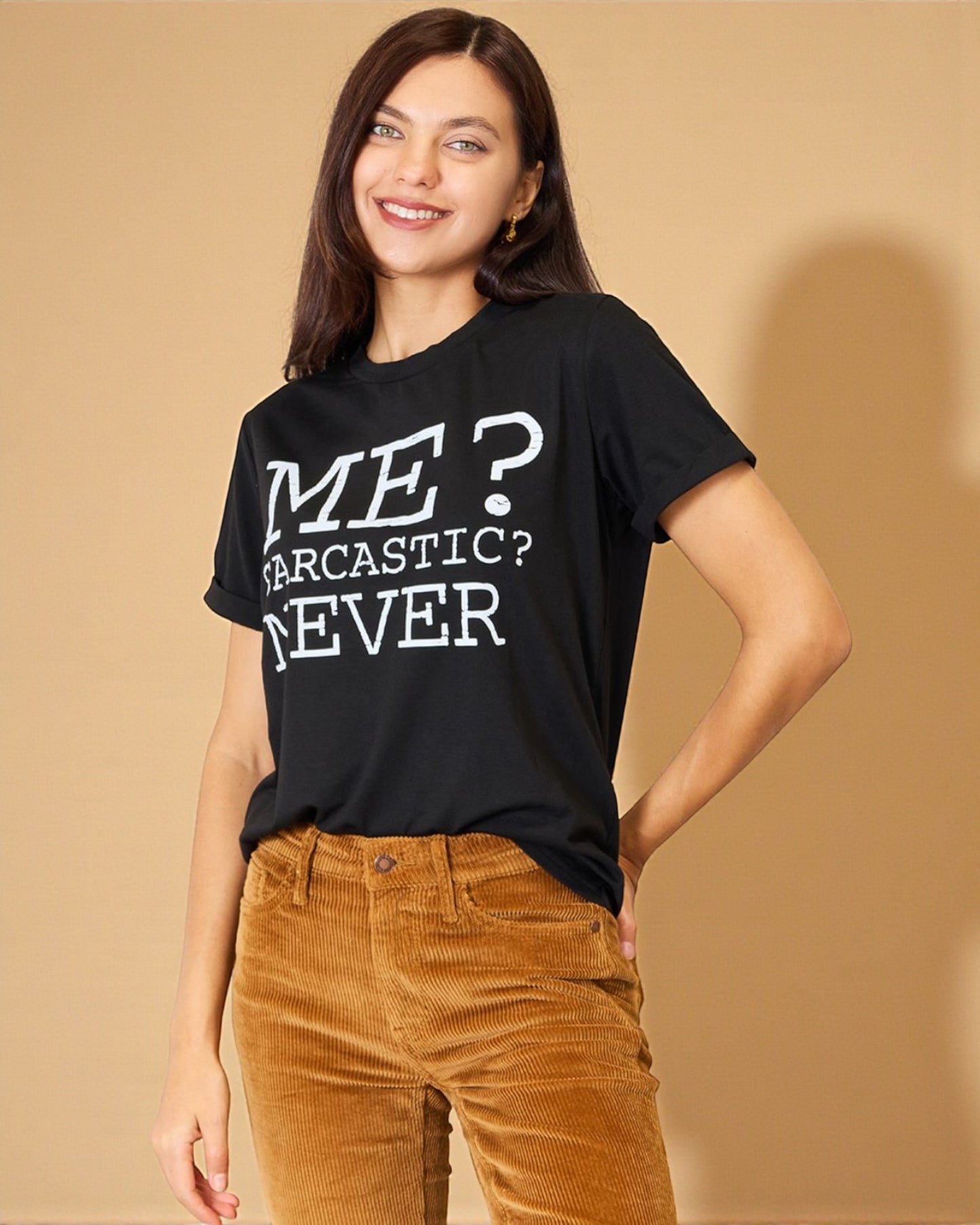 Woman wearing a black t-shirt with text, standing against a beige background