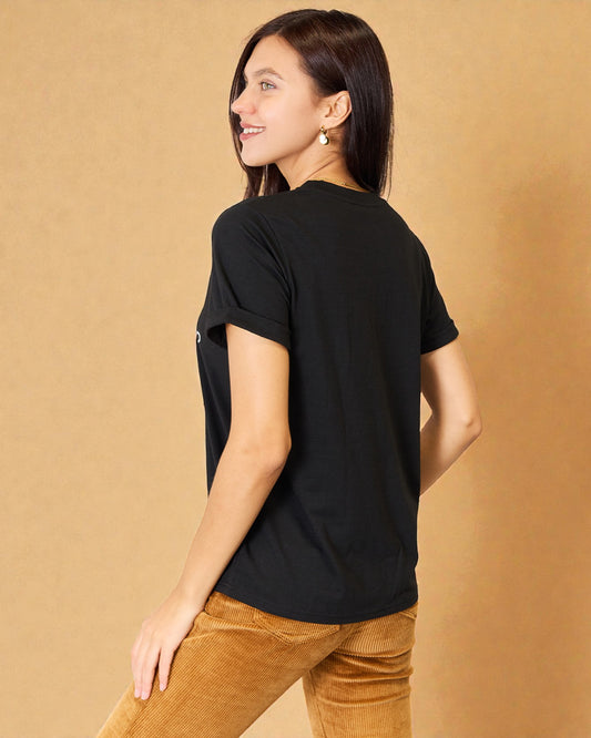 Woman wearing a black t-shirt against a beige background