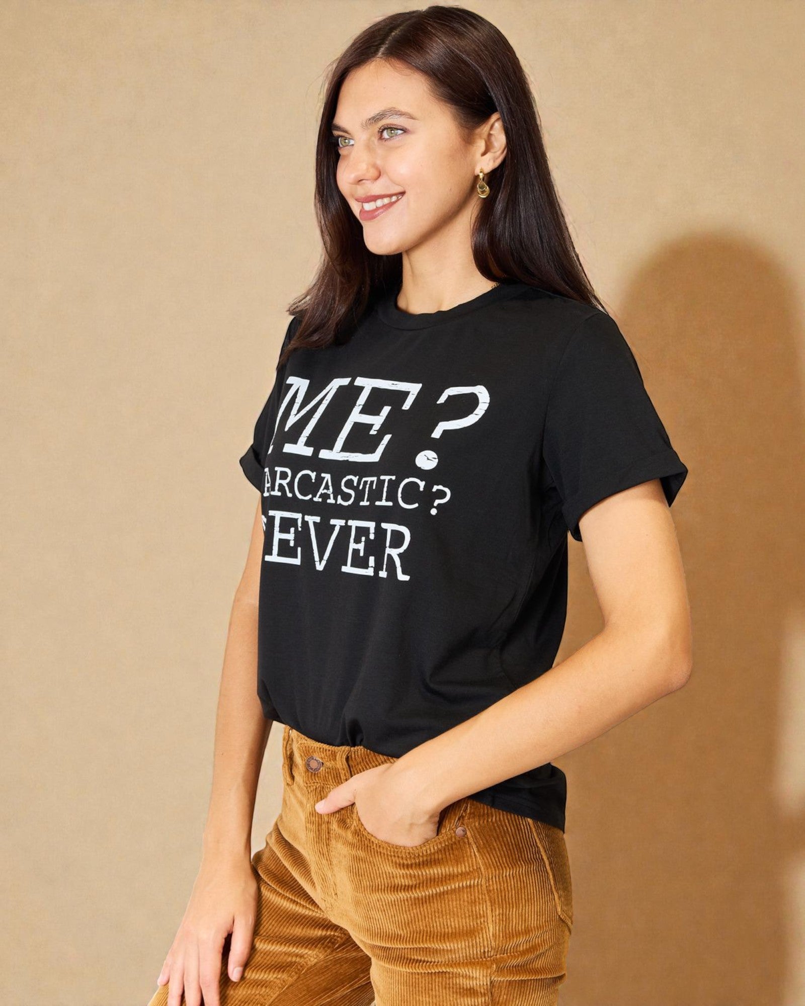 Woman wearing a black t-shirt with text, standing against a beige background