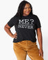 A woman modeling a black graphic t-shirt with white text that reads 'ME? SARCASTIC? NEVER'. She is wearing brown corduroy pants against a clean white background.