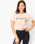 A woman wearing a light pink short-sleeve t-shirt with 'mama' written in black script and a small leopard-print heart, styled with black leggings against a light gray background.