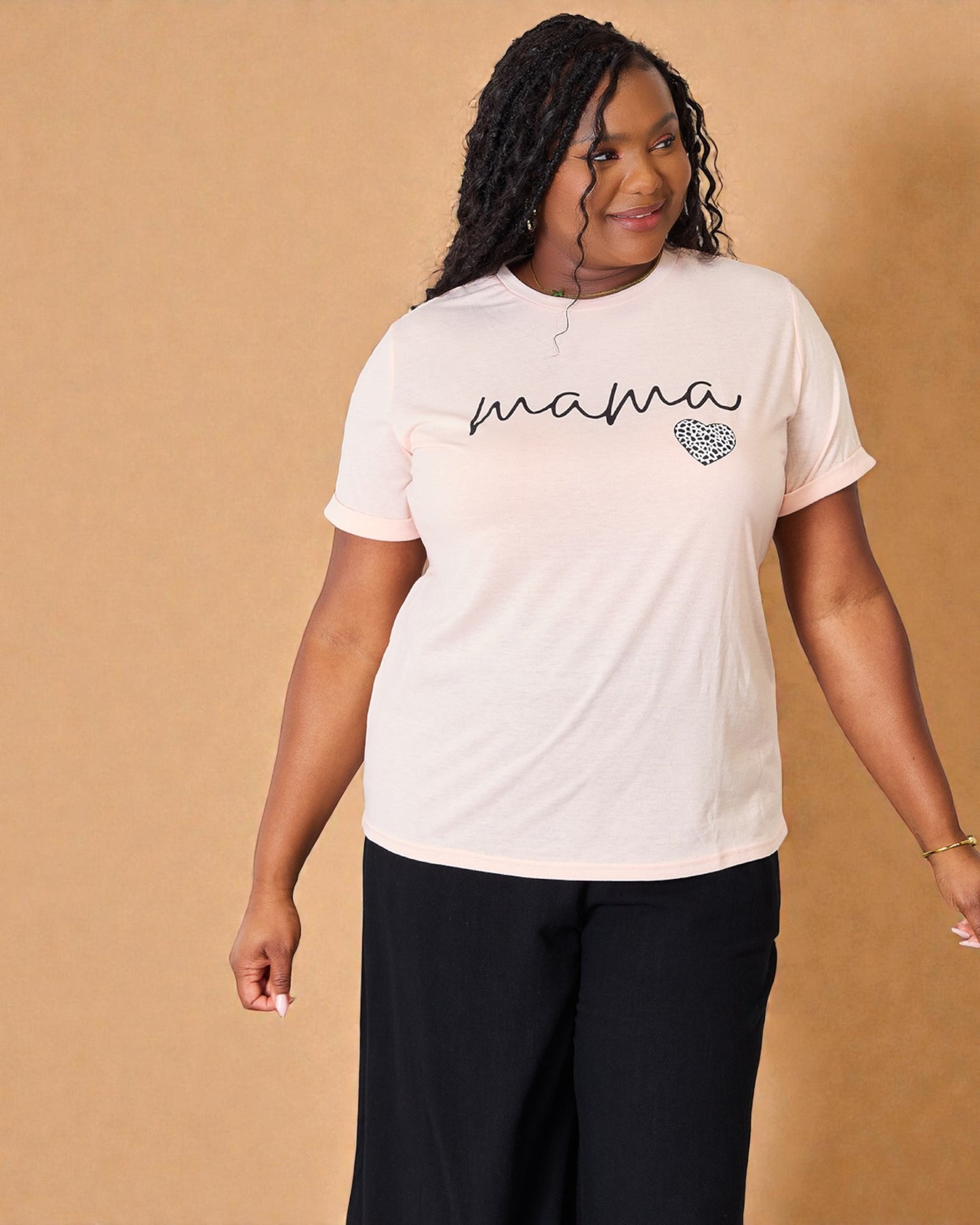 Woman wearing a white t-shirt with 'mama' and a heart design on a beige background