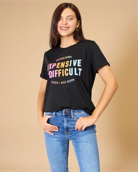 Woman wearing a black t-shirt with colorful text on a beige background