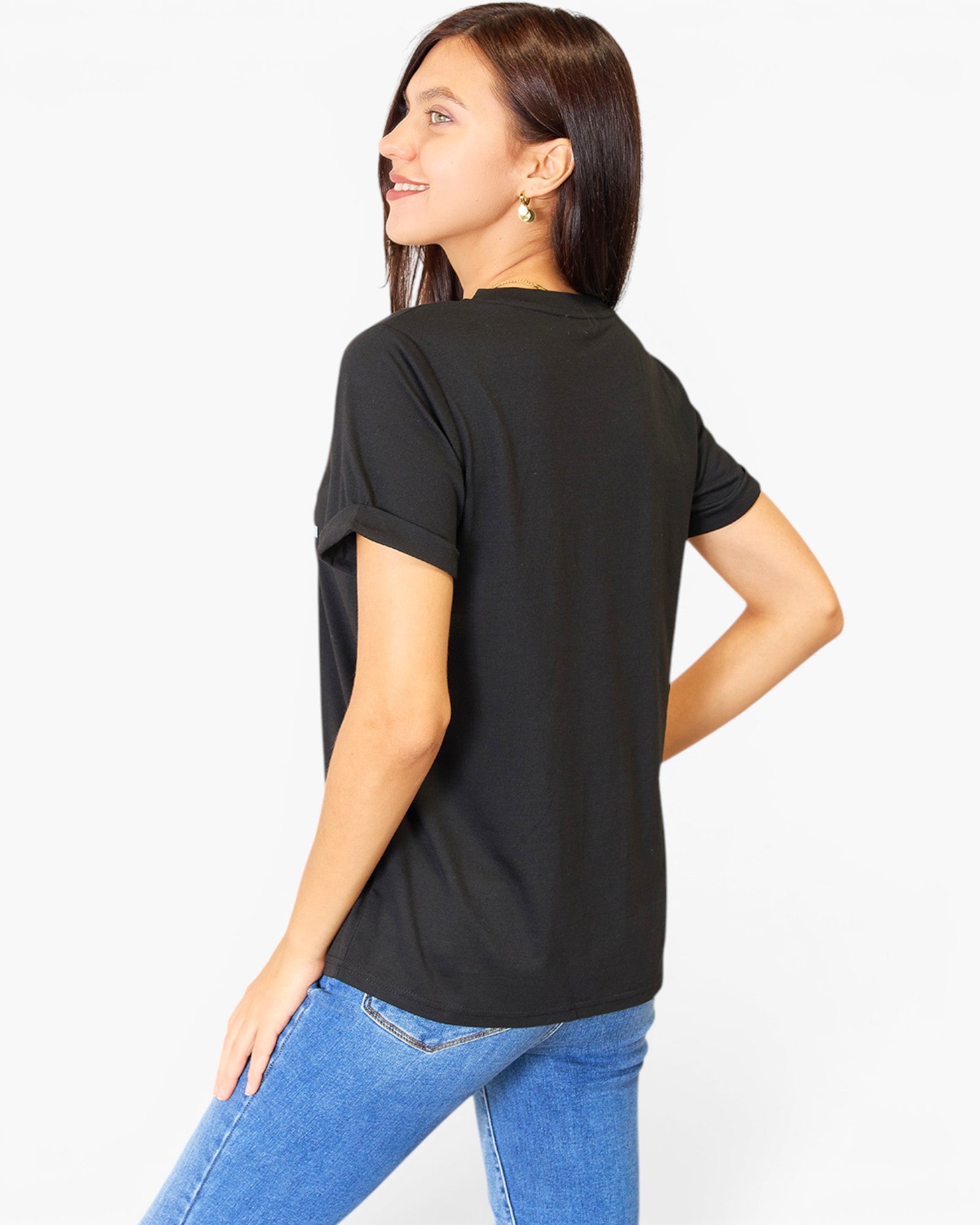 A woman wearing a black short-sleeve t-shirt and blue jeans, shown from a three-quarters back view against a plain white studio background.