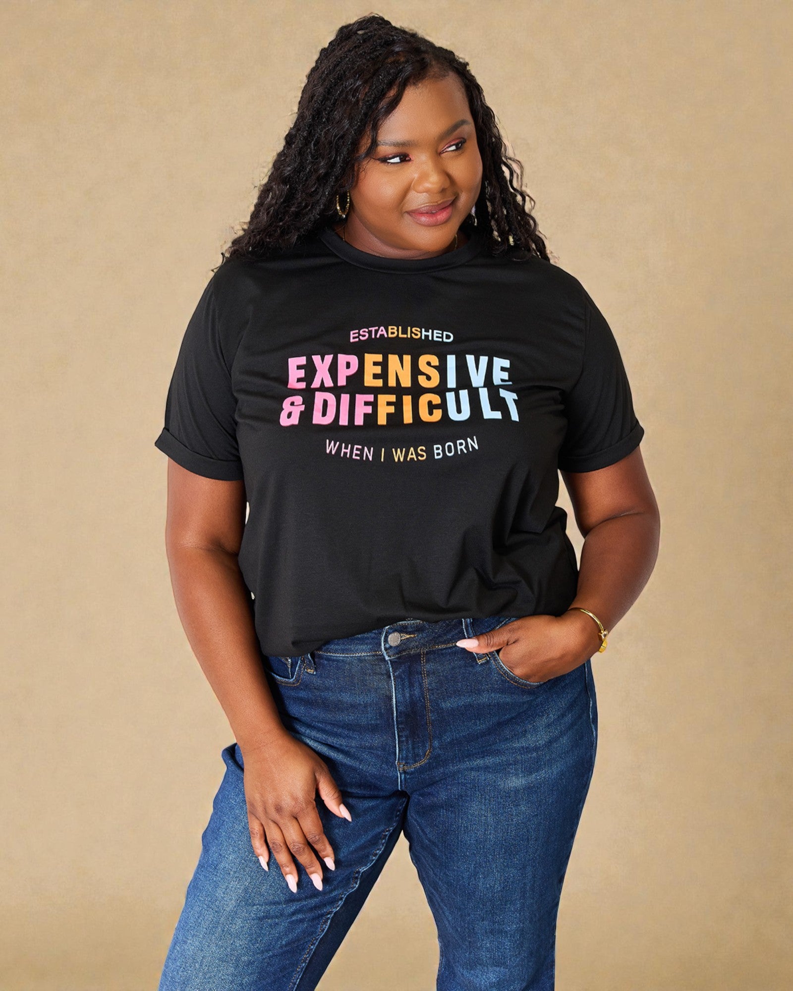 Person wearing a black t-shirt with colorful text on a beige background