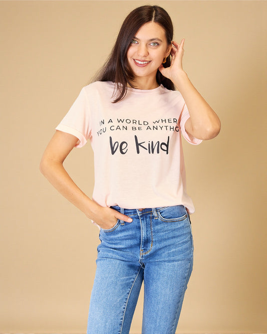 Woman wearing a pink t-shirt with a motivational quote on a beige background