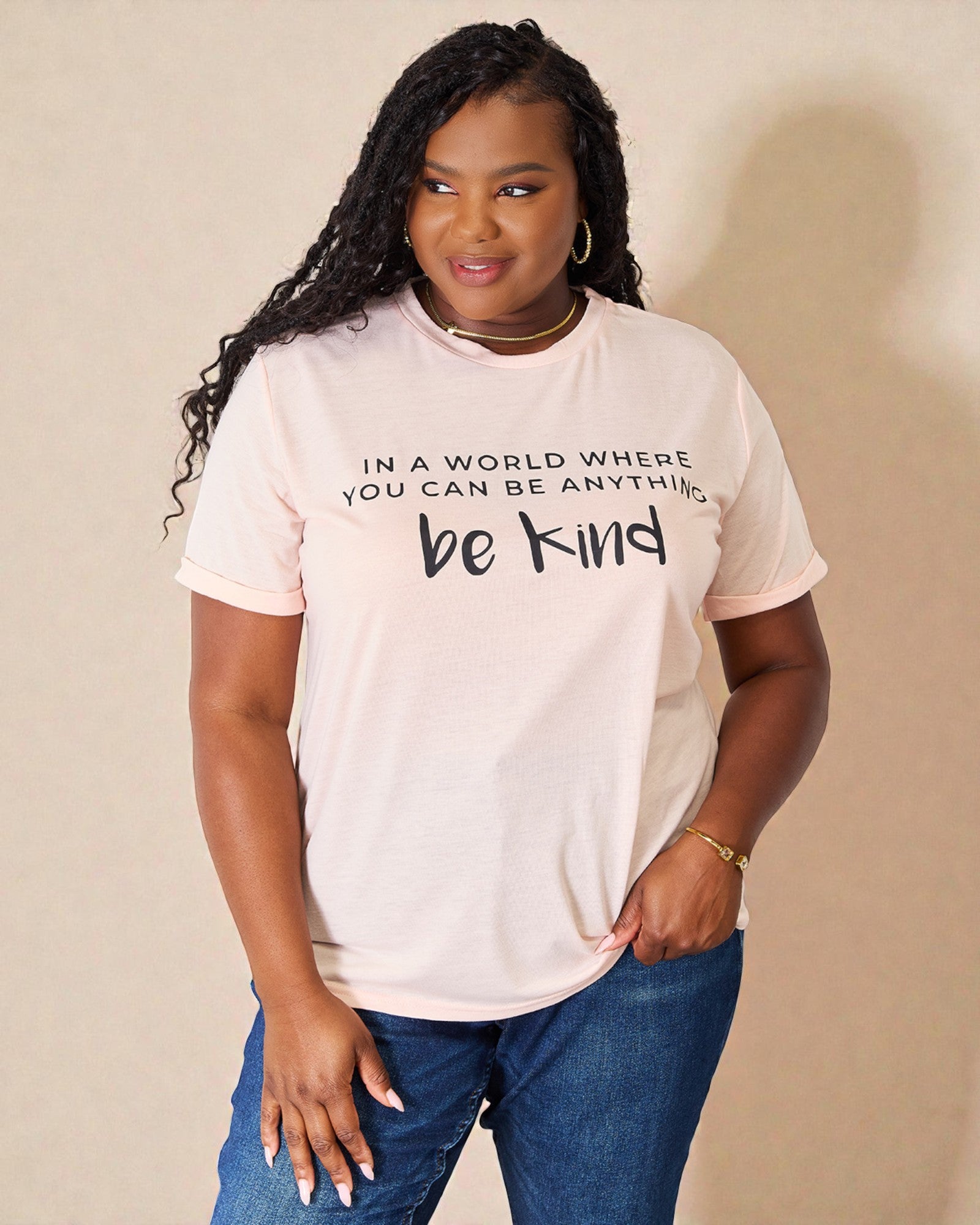 Person wearing a white t-shirt with a motivational quote on a beige background